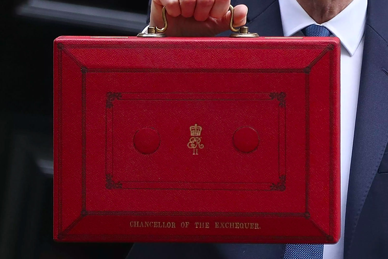 Chancellor holding up red briefcase