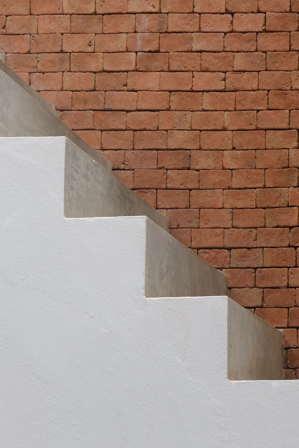 side view of concrete stairs with a brick wall