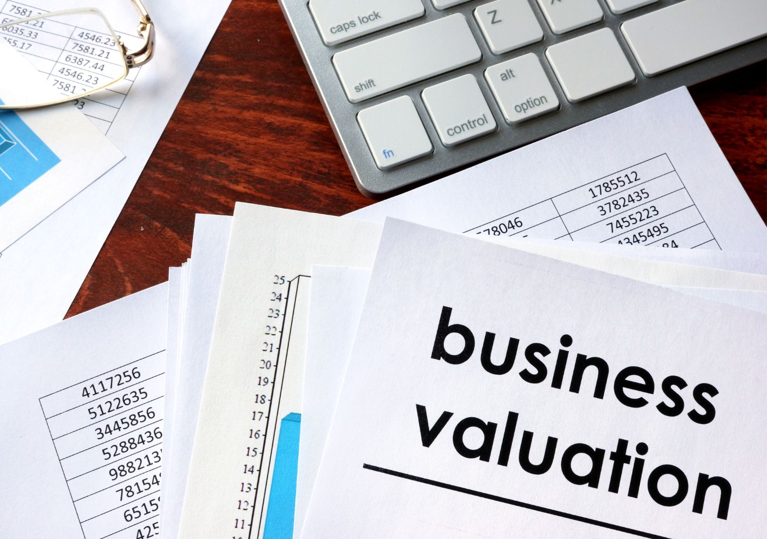 papers on desk with calculator for business valuation service