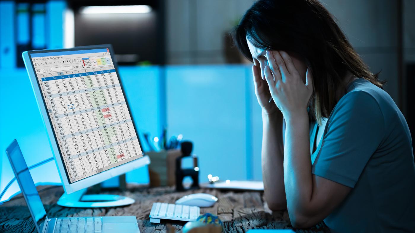 woman with head in hands at computer trying to sort accounting errors