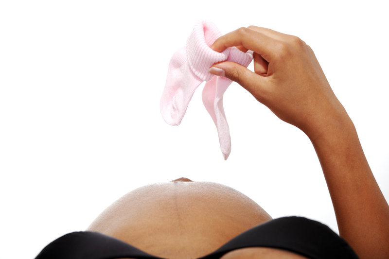 pregnant woman holding baby booties